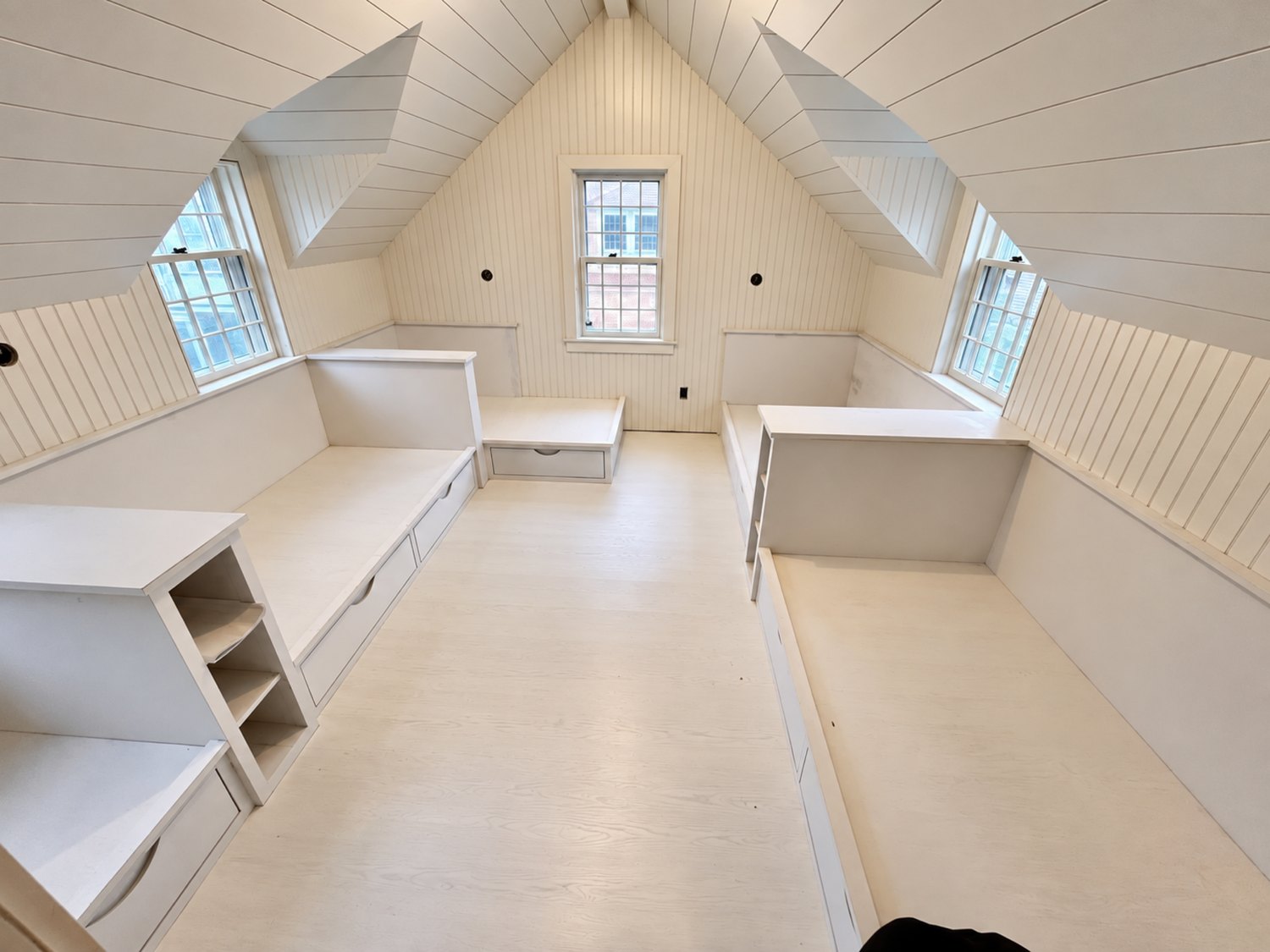 Built-in bunks and benches fitted under a sloped attic ceiling