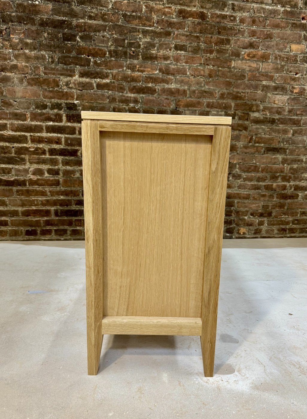 Narrow white oak cabinet with a panelled side