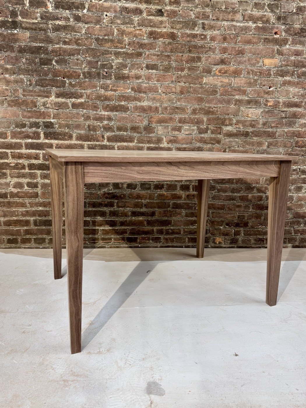 Walnut dining table with tapered legs