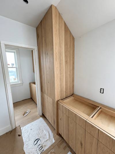 White oak entry bench with drawers and a full-height cabinet
