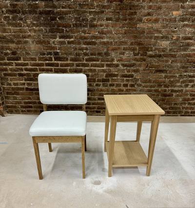 Upholstered side chair beside a small oak table with a lower shelf
