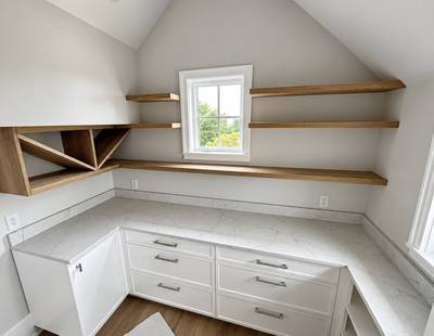 Home office with white cabinets and floating white oak shelves